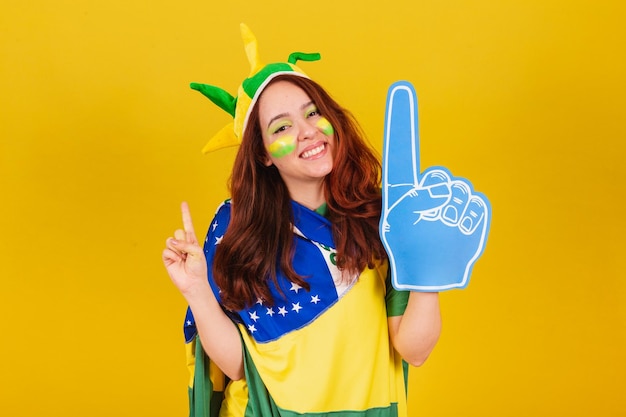 Caucasien femme rousse fan de football du Brésil à l'aide d'un doigt de mousse acclamant la danse coléographiée