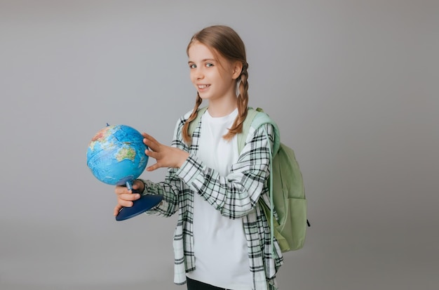 Caucasien jeune adolescent écolière étudiant tenant un globe sur un fond gris isolé Happy Earth Day