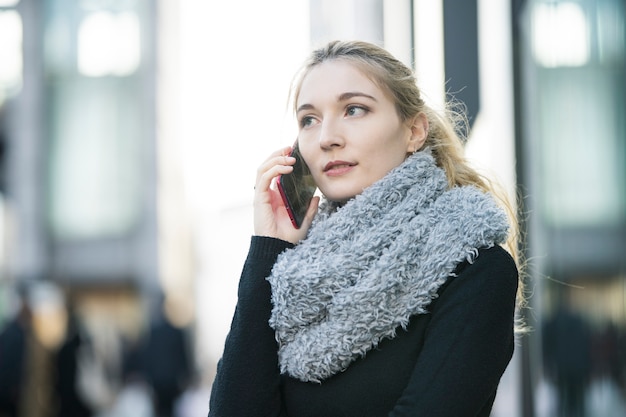 Caucasienne jeune femme parlant avec quelqu'un avec smartphone sur l'oreille