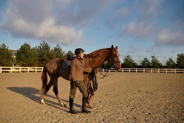 Cavalier marchant à cheval côte à côte. Trainer holding harnais selle-sangle conduisant l'étalon à l'écurie après l'entraînement à l'extérieur