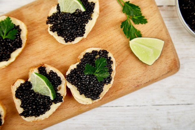 Caviar d'esturgeon noir sur toasts avec des tranches de citron