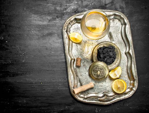 Caviar noir au vin blanc sur l'ancien plateau.