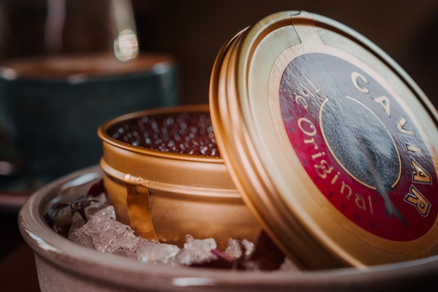 Caviar noir en boîte placé sur une assiette avec de la glace