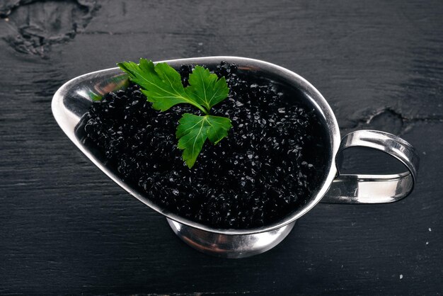 Caviar noir Caviar d'esturgeon Sur un fond en bois Vue de dessus Espace libre pour le texte