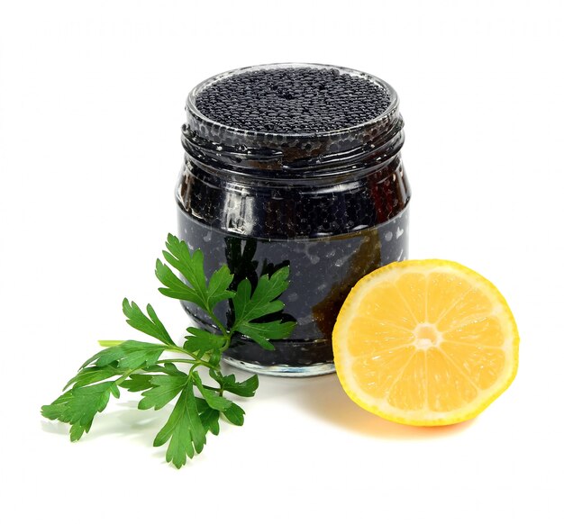 Caviar noir dans un bocal en verre avec citron et persil