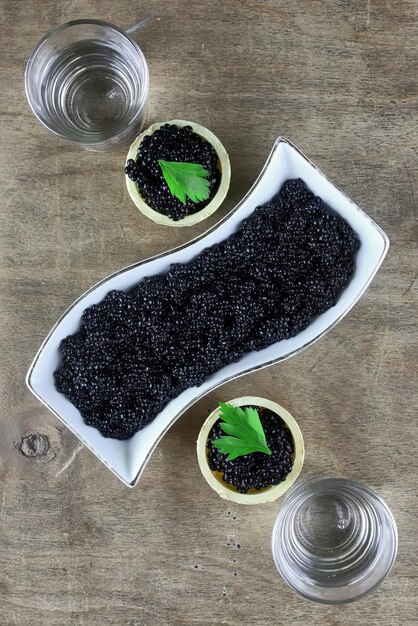 Caviar noir dans la portion sur un fond en bois