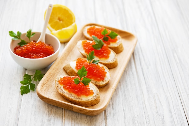 Caviar rouge dans un bol et des sandwiches