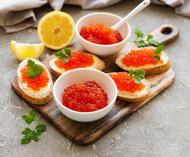 Caviar rouge dans un bol et des sandwiches