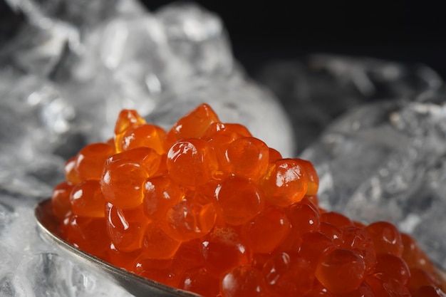 Caviar rouge dans une cuillère sur fond de glace. Caviar de saumon en gros plan. épicerie fine