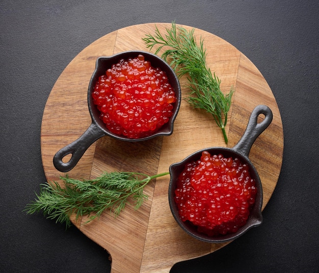 Caviar rouge dans une mini poêle à frire noire sur la table vue concept de cuisine de luxe et gourmet