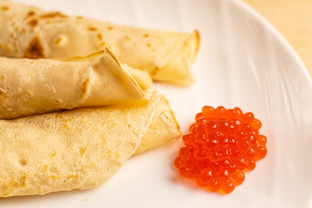 Caviar rouge avec de grandes crêpes blanches sur une assiette blanche Jours de Shrovetide