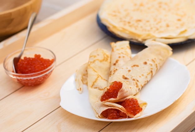 Caviar rouge avec de grandes crêpes blanches sur une assiette blanche Jours de Shrovetide