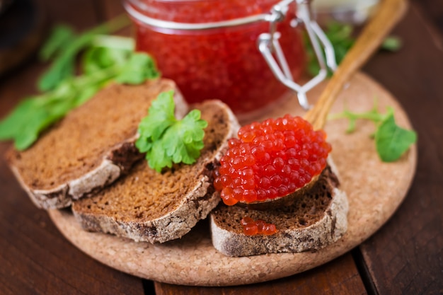 caviar rouge à l'intérieur d'un bocal en verre avec des tranches de pain