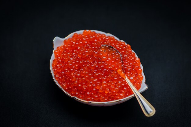 Caviar rouge sur une surface noire