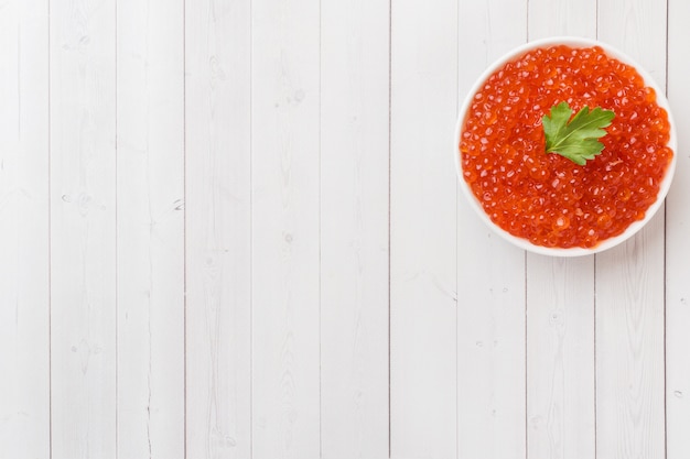 Caviar de saumon rouge dans une assiette sur une table blanche. Espace de copie