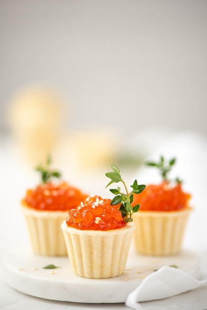 Caviar de saumon rouge salé en tartelettes décorées de brins de thym, close-up