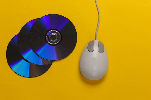 CD rétro à l'ancienne et souris pc sur jaune