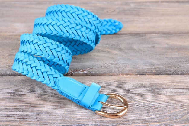 Ceinture en cuir bleu sur fond de bois