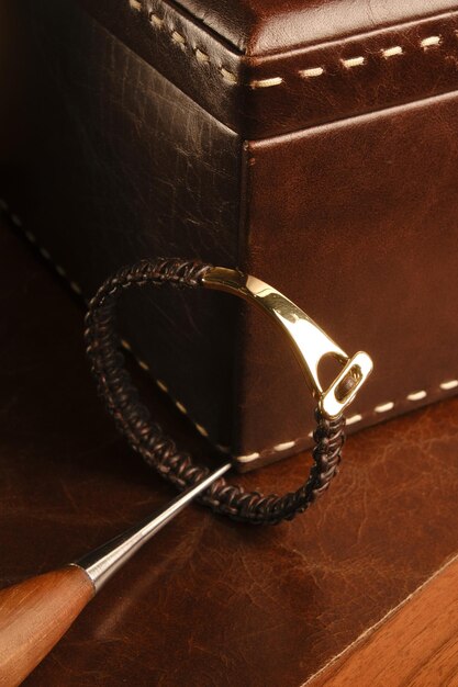 une ceinture en cuir avec une boucle en or est sur une surface en cuir brun