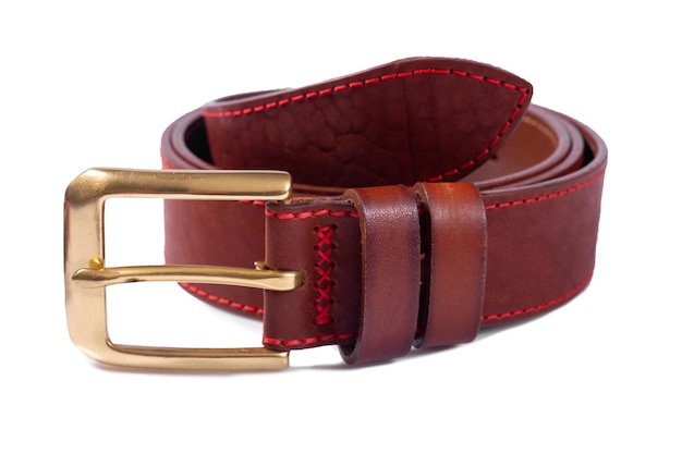 Une ceinture en cuir marron enroulée avec une boucle en métal sur fond blanc est isolée