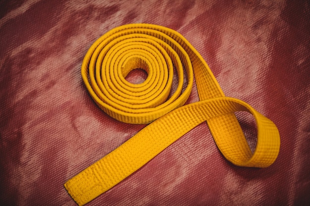 Ceinture jaune de karaté sur fond rouge