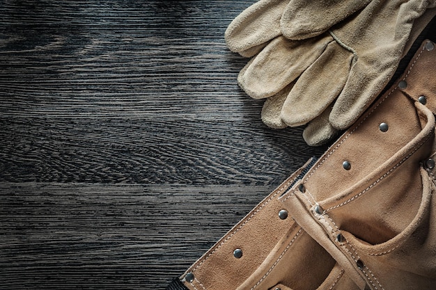 Ceinture à outils en cuir gants de protection sur tableau noir