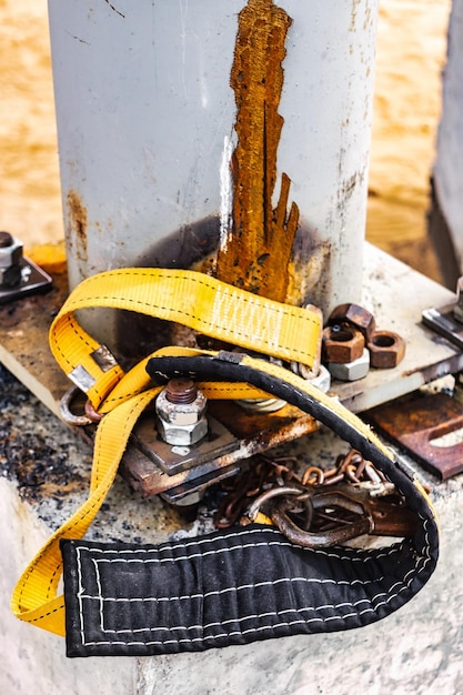 La ceinture de sécurité d'un soudeur ou d'un assembleur repose sur une fondation en béton sur un chantier de construction Protection d'une personne travaillant en hauteur Ingénierie de la sécurité