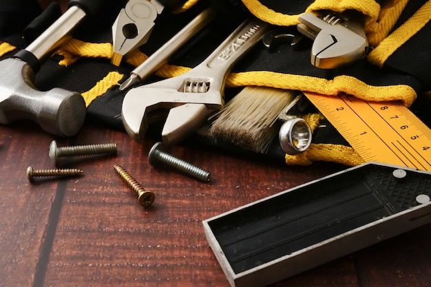 Ceinture de travailleur de la construction avec des outils sur fond de table en bois.