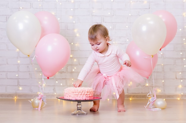 Célébration d'anniversaire drôle de petite fille brisant le gâteau