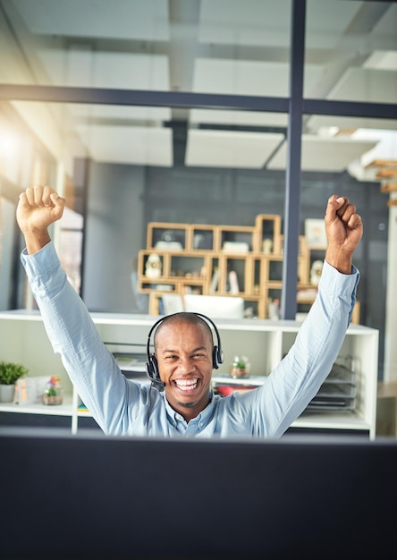 Photo célébration du centre d'appels et heureux homme noir gagnant au bureau pour le succès de la vente de conseil et la communication gagnant du télémarketing et consultant masculin pour le support et le réseau du service client crm