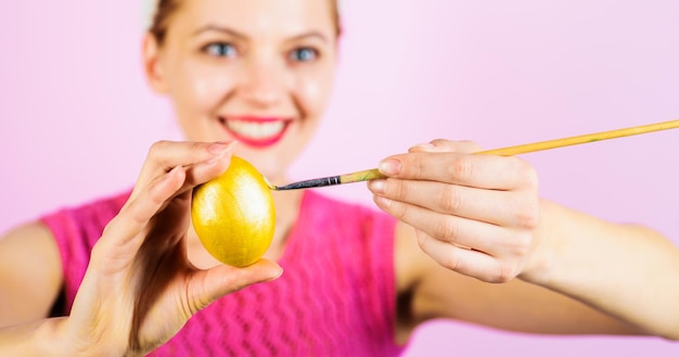 Célébration du jour de pâques femme souriante peignant des oeufs idées de décoration d'oeufs de pâques