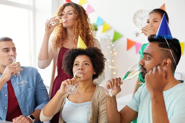 Photo célébration d'entreprise et vacances concept d'équipe heureuse buvant du vin mousseux non alcoolisé à la fête d'anniversaire au bureau