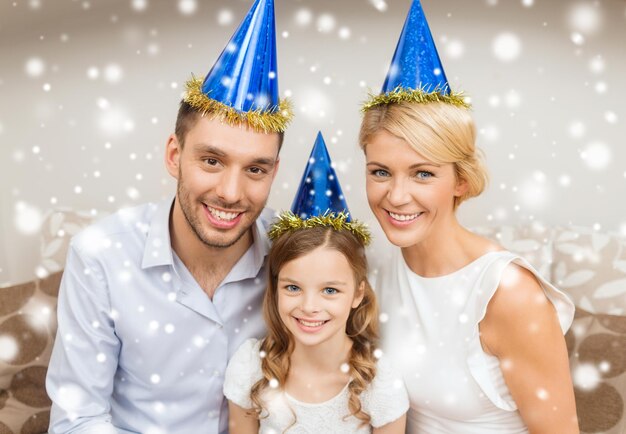 célébration, famille, vacances et concept d'anniversaire - famille heureuse portant des chapeaux de fête bleus à la maison