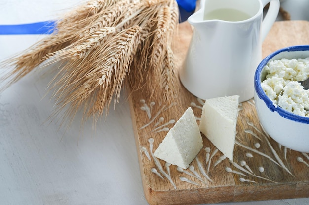 Célébration de la fête juive de Chavouot Produits laitiers frais casher lait et fromage crème de blé mûr sur fond en bois blanc Produits laitiers sur fond en bois blanc Concept de Chavouot Vue de dessus