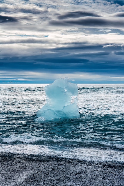 Photo célèbre plage de diamants avec iceberg fondant sur une plage de sable noir près de la lagune glaciaire de jökulsárlón en été au sud de l'islande