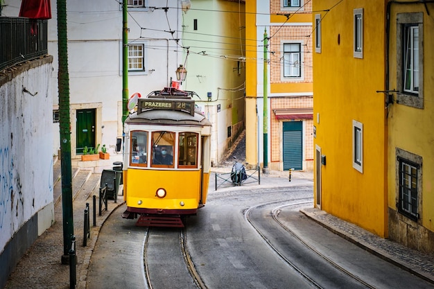 Célèbre tramway jaune vintage dans les rues étroites du quartier d'alfama à lisbonne portugal