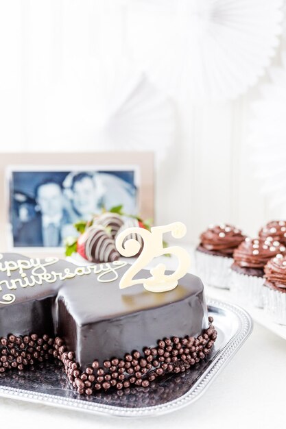 Célébrer l'anniversaire de mariage avec un gâteau au chocolat en forme de coeur.