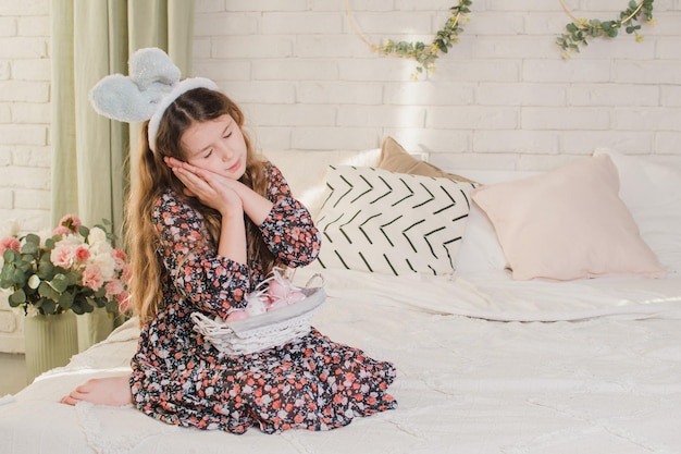 Célébrer la fille de Pâques avec des oreilles de lapin au lit