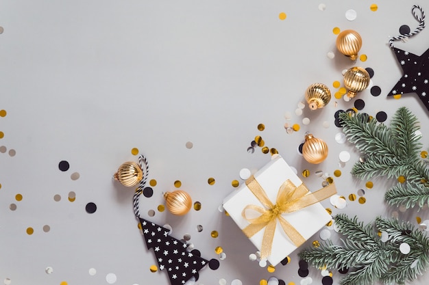 Célébrer la mise à plat avec des décorations du nouvel an, des confettis de boules dorées présentent un fond gris