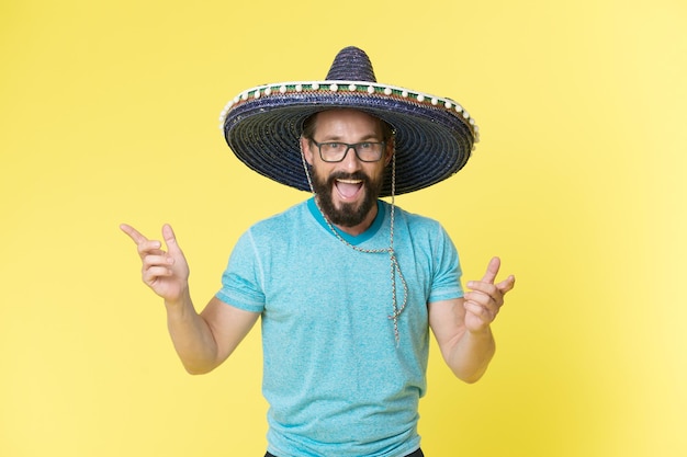 Célébrer les traditions Homme sur un visage souriant dans un chapeau sombrero célébrant le fond jaune Un gars avec une barbe a l'air festif dans le sombrero Fest et le concept de vacances Homme d'humeur festive à la fête célébrant