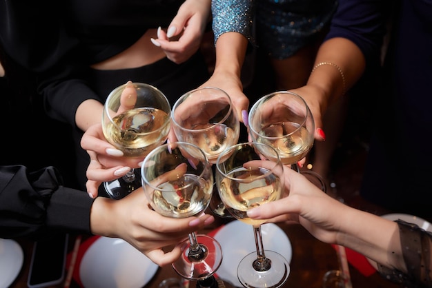 Célébrer avec des verres d'alcool dans les mains des amies heureuses s'amusant