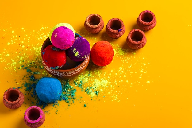 Célébrez le festival indien holi, boule multicolore sur surface jaune