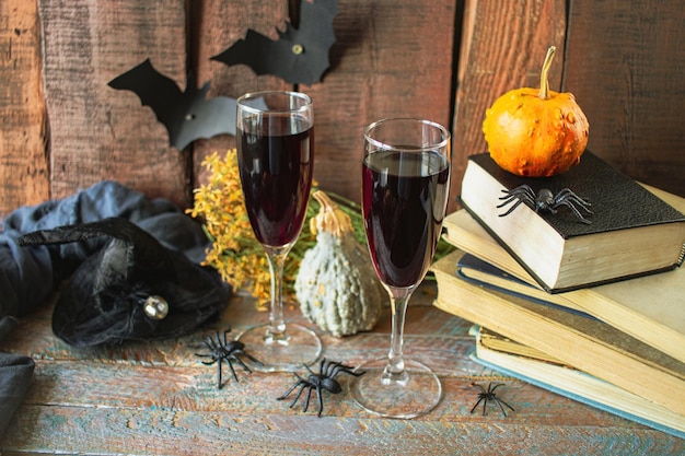 Célébrez Halloween deux verres de vin rouge livres vintage citrouilles et décorations d'Halloween