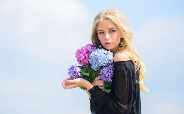 Célébrez le printemps avec un bouquet. Le mannequin fille tendre tient un bouquet de fleurs d'hortensia. Rencontrez le printemps avec un bouquet frais. Fleurs au parfum tendre. Bouquet pour petite amie. Industrie de la mode et de la beauté.