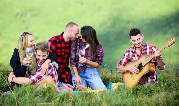 Célébrez les vacances Groupe d'amis pique-nique relaxant Les amis profitent des vacances Pique-nique en randonnée Les gens mangent de la nourriture Les jeunes s'amusent en pique-nique dans les hautes terres Aventures d'été Randonnée avec guitare Loisirs dans la nature