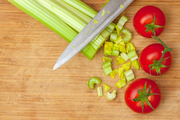 Céleri et tomates sur une planche à découper