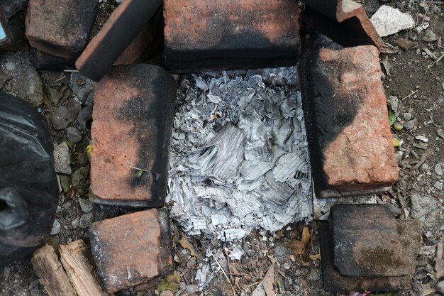 Photo les cendres et le charbon sont refroidis après la combustion. feu éteint entouré de briques.