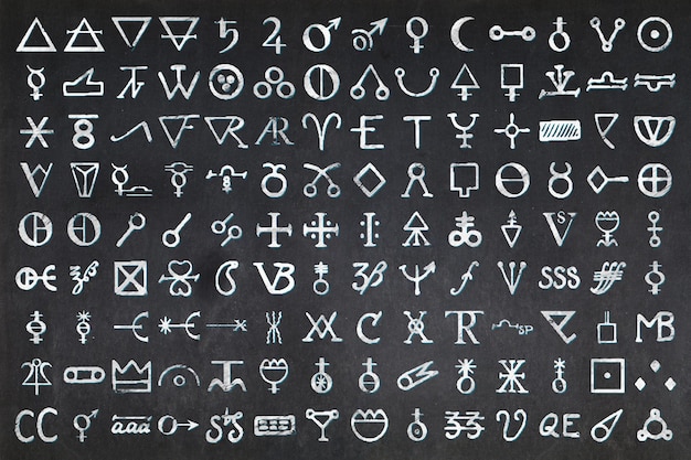 Photo des centaines de glyphes utilisés en alchimie dessinés sur un tableau noir