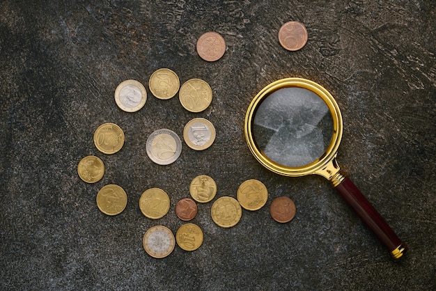 Centimes d'euro et une loupe sur fond sombre