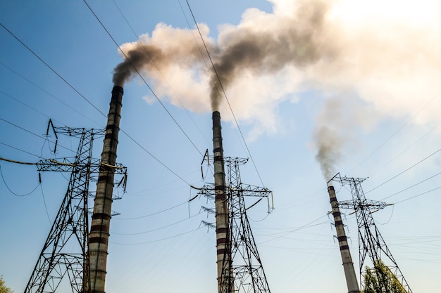 Centrale électrique à charbon fonctionnant avec des cheminées. Fumée sale dans le ciel, problèmes écologiques.